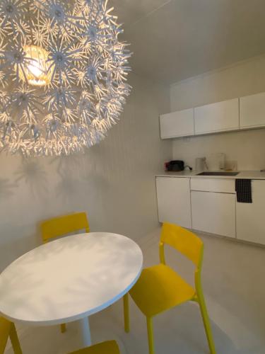 a kitchen with a table and chairs and a chandelier at Gardermoen House in Gardermoen