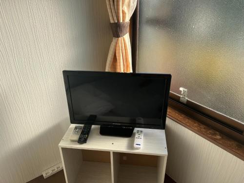 a computer monitor on a table with a remote control at Guest house HEART - Vacation STAY 98734v in Hitoyoshi