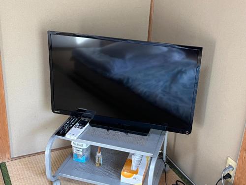 a large computer monitor on a stand with a keyboard at Guest house HEART - Vacation STAY 98762v in Hitoyoshi