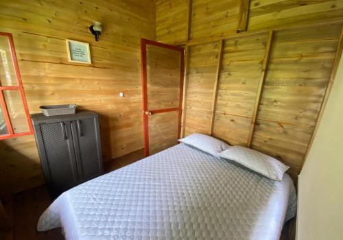 1 dormitorio con 1 cama en una cabaña de madera en Mirador La Colina Campo, en San Francisco