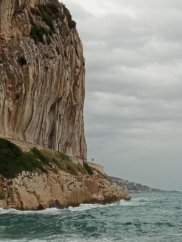 a rocky cliff next to a body of water at Voilier tout confort in Beaulieu-sur-Mer