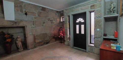 Habitación con pared de piedra, puerta y chimenea. en Varandas do Dão & Estrela, 