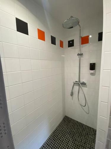 La salle de bains est pourvue d'une douche et d'un mur en carrelage noir et blanc. dans l'établissement Maison de charme - proche Futuroscope, à Montamisé