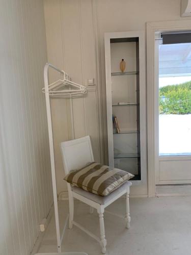 a chair in a room with a shelf and a window at Gardermoen House in Gardermoen