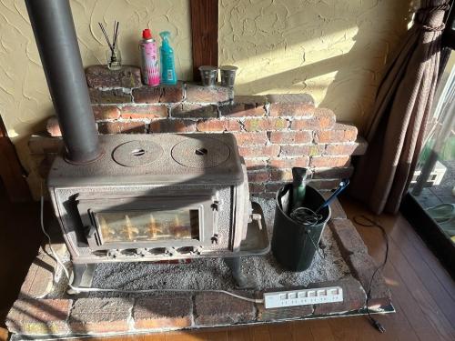 a brick fireplace with a stove in a room at Guest house HEART - Vacation STAY 04626v in Hitoyoshi