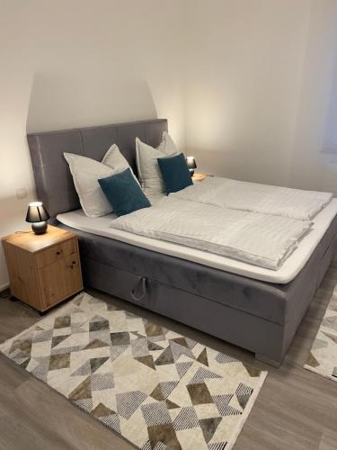 - un lit avec des draps blancs et des oreillers bleus dans une chambre dans l'établissement to be apartments Deluxe-Suites, à Weiden