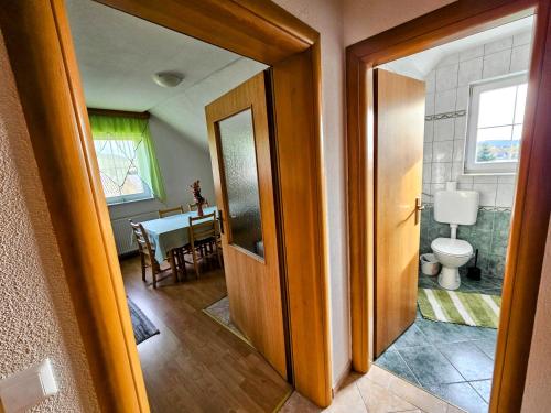 einen Flur mit einer Tür, die zu einem Zimmer mit WC führt in der Unterkunft Apartman M. Rados in Kupres