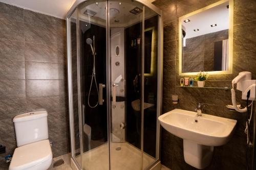 a bathroom with a toilet and a sink and a shower at Sun and Sand Guest House in Cairo