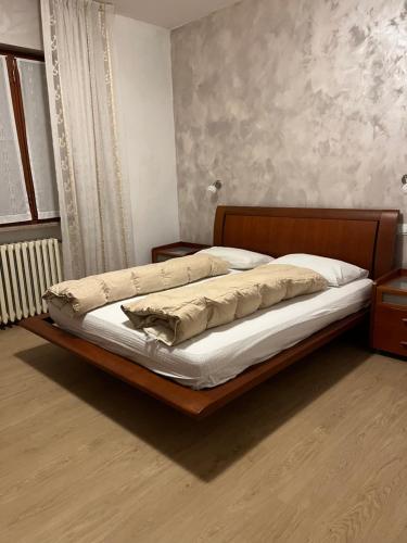 a bed with a wooden frame in a bedroom at Locanda Seggiovia in Recoaro Terme