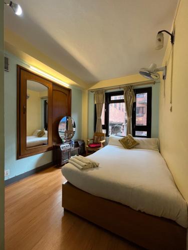 a bedroom with a large bed and a large window at Golden Gate Guest House in Bhaktapur