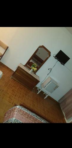 ein Wohnzimmer mit einem Tisch und einem Spiegel in der Unterkunft Residencial/ Pensão Natur in Tarrafal