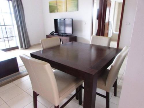 a dining room table with white chairs and a television at Peaceful Paradise at Tortuga Beach - 473 in Prainha
