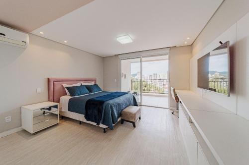 um quarto com uma cama e uma grande janela em 802 Maison Duplex para pessoas de bom gosto. em Joinville
