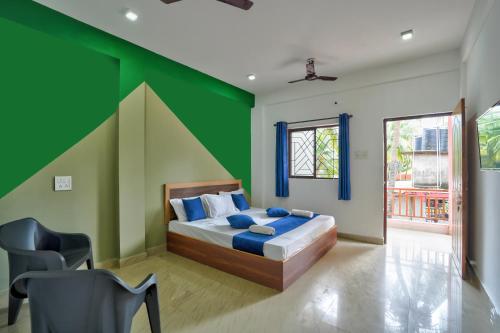 a bedroom with a bed and a green wall at Abbi's Nest Beach House Goa in Calangute