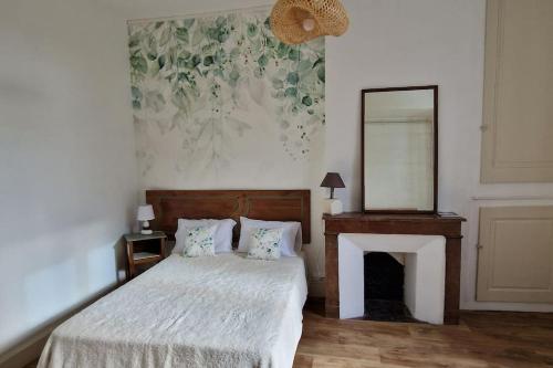 a bedroom with a bed with a fireplace and a mirror at Au coin caché in Dole