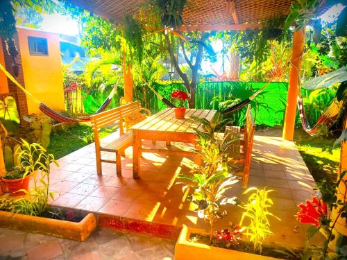 eine Terrasse mit einer Bank, einem Tisch und Pflanzen in der Unterkunft Art & Coffee in Santa Cruz La Laguna
