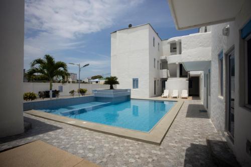 a swimming pool in front of a white building at COMODO DEPARTAMENTO CERCA DE LA PLAYA WIFFI in Tonsupa
