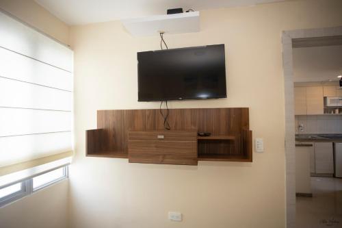 a flat screen tv hanging on a wall at COMODO DEPARTAMENTO CERCA DE LA PLAYA WIFFI in Tonsupa