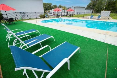 un grupo de sillas sentadas junto a una piscina en Gulfport 2 br Apt # 1309, en Gulfport