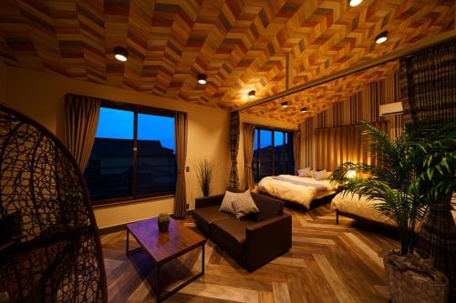 een woonkamer met een bed en een bank bij Kiseki no Aoi Tennenonsen - Vacation STAY 15697 in Beppu