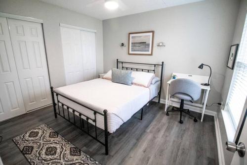 1 dormitorio con cama, escritorio y silla en Gulfport 2 br Apt # 1309, en Gulfport