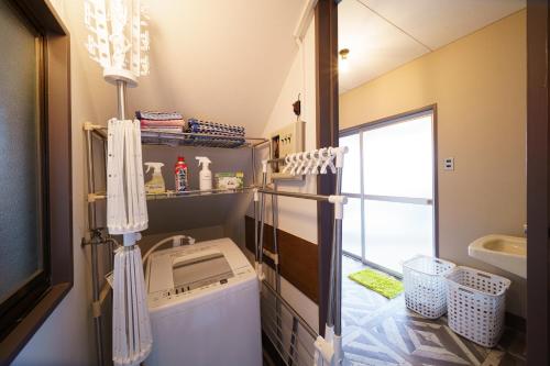 a bathroom with a washing machine and a sink at Kiseki no Aoi Tennenonsen - Vacation STAY 15697 in Beppu