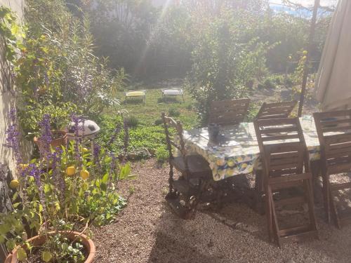 - un jardin avec une table, des chaises et des fleurs dans l'établissement "Chambre" Chez Zabou, à Carpentras