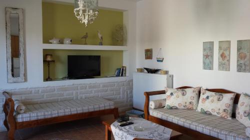 ein Wohnzimmer mit 2 Sofas und einem TV in der Unterkunft Sirines Apartments in Palekastro