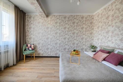 um quarto com uma cama, uma cadeira e uma mesa em Уютная квартира в ЖК Уш Сункар с видом на горы em Almaty