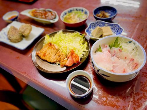 een tafel met borden en schalen van voedsel bij Ryokan Warajisha - Vacation STAY 80171v in Goto