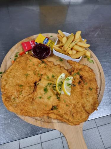 a plate of food with a fish and french fries at Haiminger Hof in Haiming