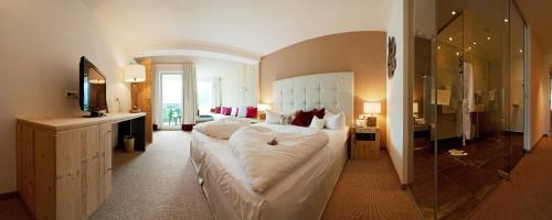 a large bedroom with a large bed and a bathroom at Alpenhotel Stefanie in Mayrhofen
