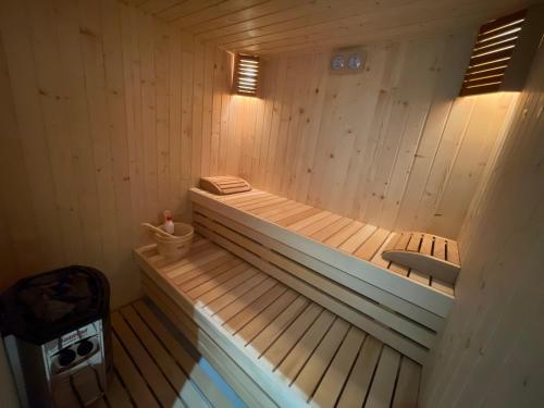 a wooden sauna with a tub and a sink at Ambassador Skyline Apartments in Tirana