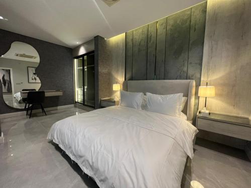 sypialnia z dużym białym łóżkiem i biurkiem w obiekcie برج كابانا للوحدات السكنية w Rijadzie