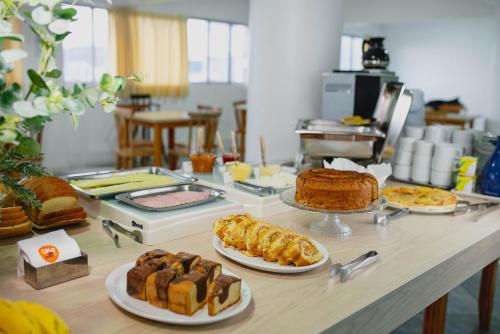 a table with several different types of bread and pastries at Ok Inn Hotel Floripa - SOB NOVA GESTÃO in Florianópolis