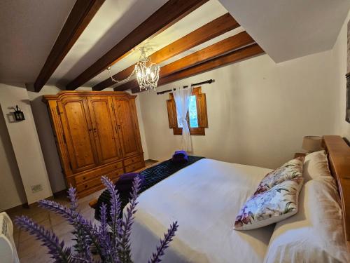a bedroom with a large bed and a chandelier at Casa Turistica Torreón de Villafamés in Villafamés