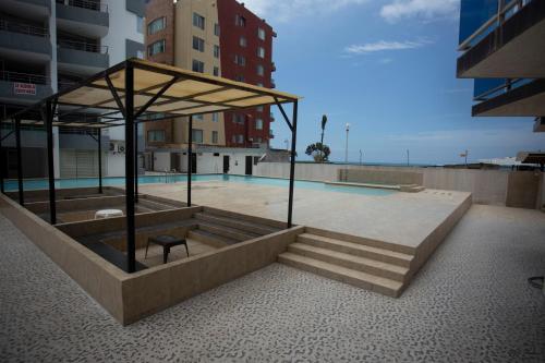 eine Bank auf einem Gebäude mit Pool in der Unterkunft DEPARTAMENTO DE LUJO FRENTE AL MAR, WIFFI PISO 8 in Tonsupa