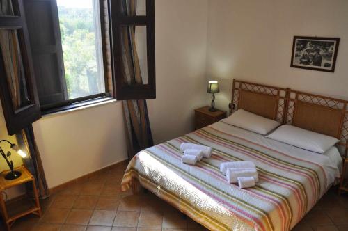 ein Schlafzimmer mit einem Bett mit zwei Handtüchern darauf in der Unterkunft Casa Capperi in Noto Marina