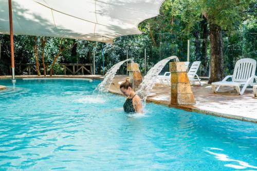 a young child playing in a swimming pool at Hotel y Termas Huife in Termas De Huife