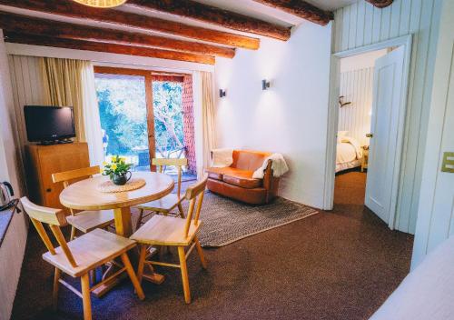 a living room with a table and chairs and a couch at Hotel y Termas Huife in Termas De Huife