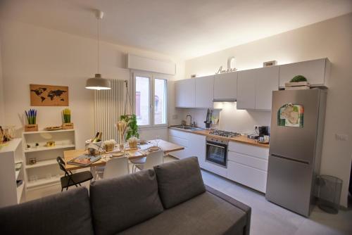uma cozinha com um sofá, uma mesa e um frigorífico em LikeHome Apartment -3Rooms - 10persone -Ferrara em Ferrara