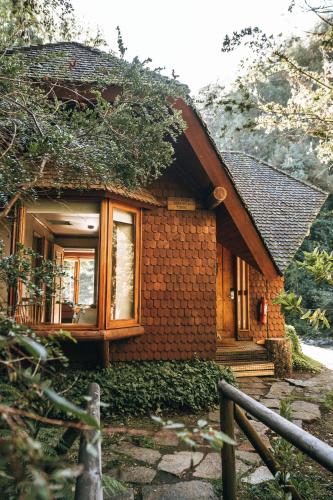 a small brick house with a window and a fence at Hotel y Termas Huife in Termas De Huife