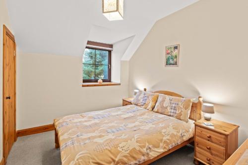 a bedroom with a bed and a window at Freuchies Mill - A Holiday Home For All Seasons. in Blairgowrie