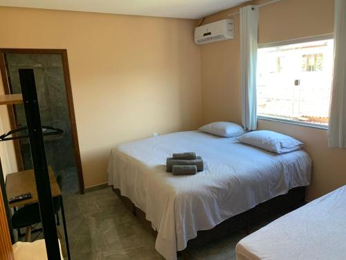 - une chambre avec un lit avec deux oreillers et un miroir dans l'établissement Pousada Licuri Ibicoara, à Ibicoara