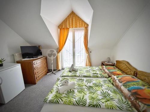 Un dormitorio con una cama grande y una ventana en Főnix Wellness ** Apartman, en Hévíz