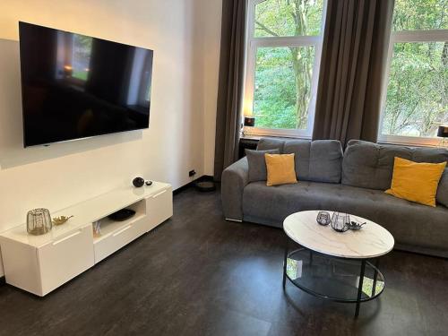 a living room with a couch and a flat screen tv at Auszeit am Meer 5 Gehminuten zum Südstrand, Gemütliche 75 Quadratmeter Wohnung,Hochparterre in Wilhelmshaven