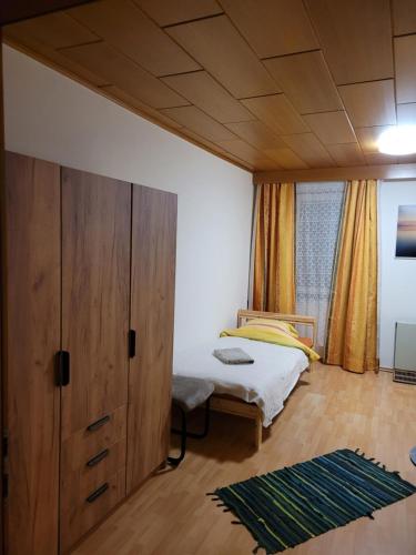 Ferienwohnung Max في مورزشلاغ: غرفة نوم مع سرير وخزانة خشبية كبيرة