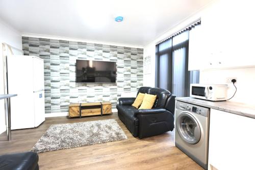 a kitchen and living room with a washer and dryer at Studio 22 Lower Road Beeston in Nottingham