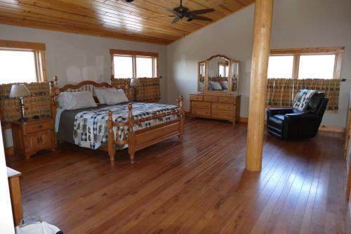 a bedroom with a bed and a chair in a room at Mountain Maryland! Bear in the Woods in Grantsville