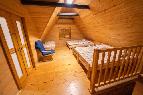 a attic room with two beds and a staircase at Chata Domaša - Nová Kelča in Valkov